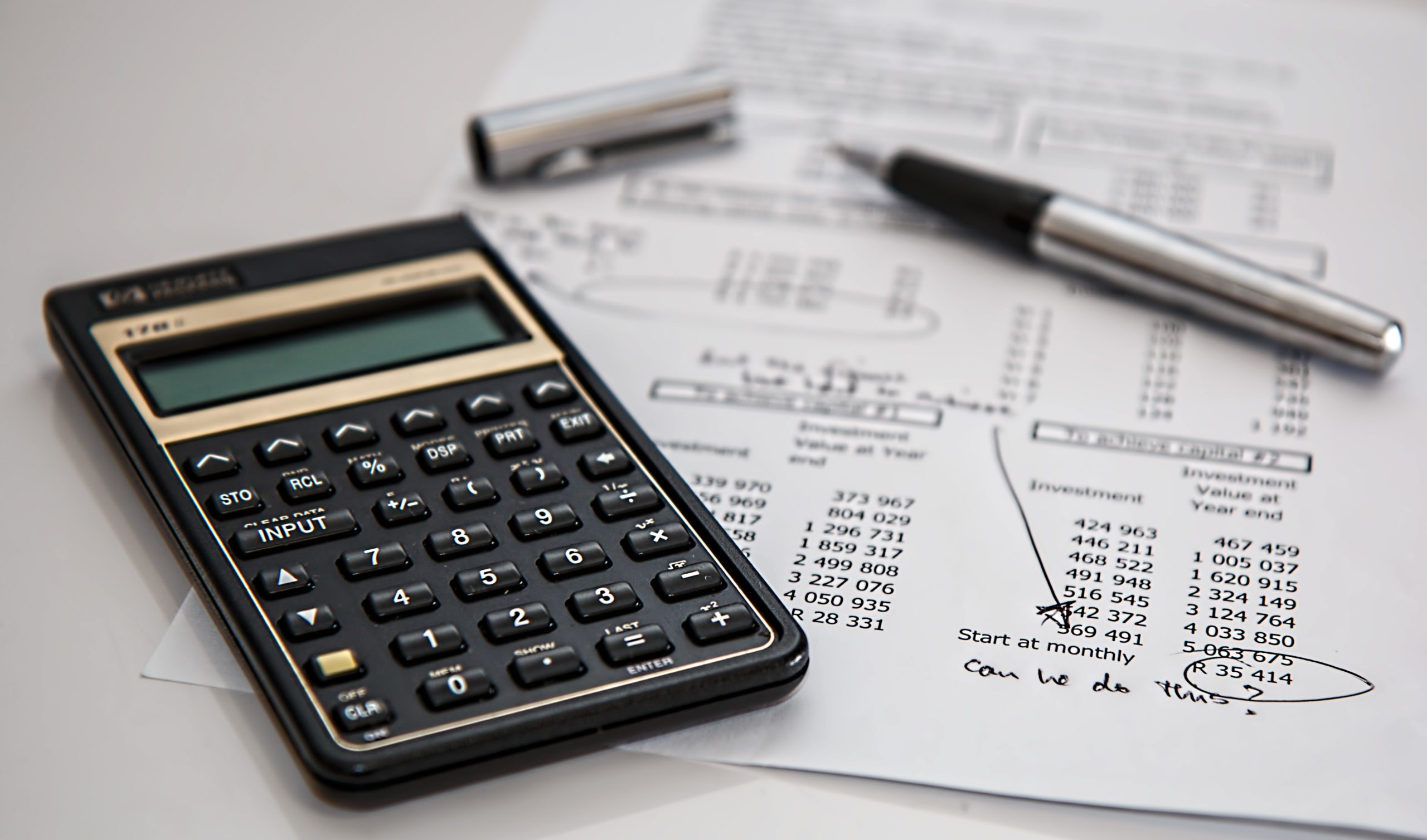 Pen, financial calculator, and budget printout